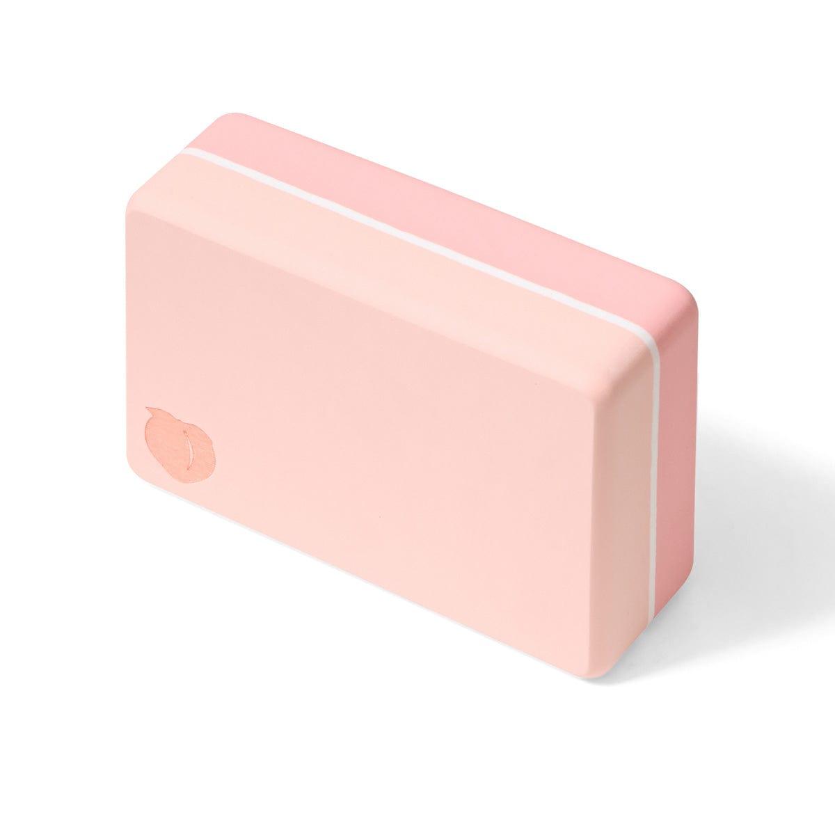 Pink yoga block with rounded edges and white stripes
